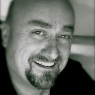 black and white portrait of shawn smith: he smiles, has beard 